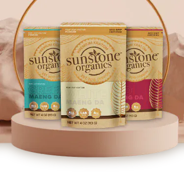 Sunstone Organics kratom products on a round platform with a soft pink background