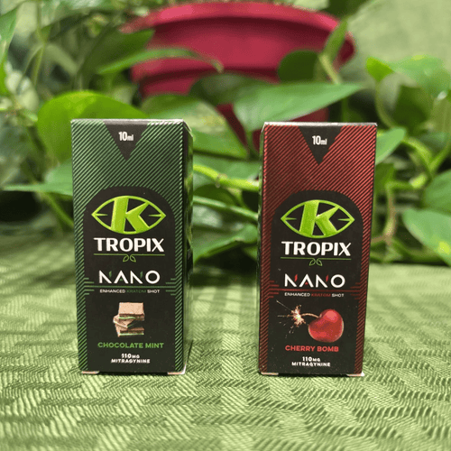 Two Tropix Nano packaging boxes on a textured green surface with plants in the background.